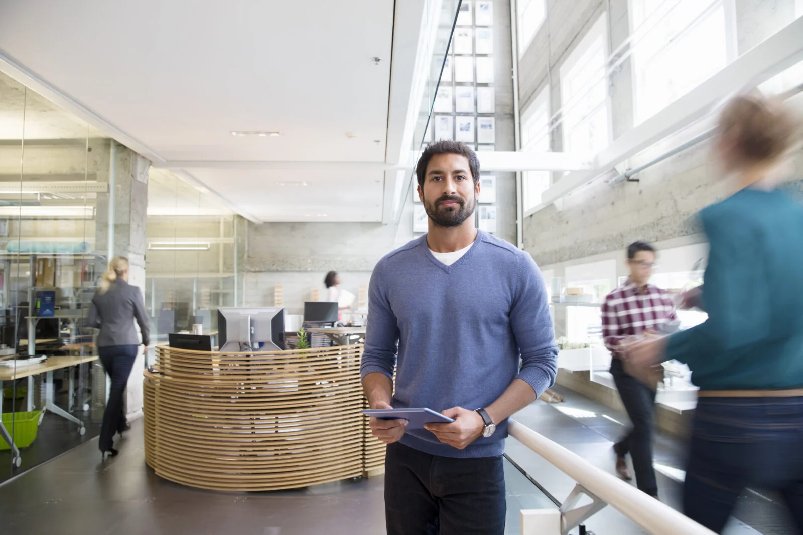 Man holding tablet in modern office, showing why a well-being strategy needs to support the whole workforce