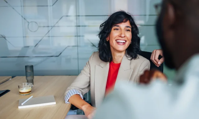 Smiling woman in professional interview setting.