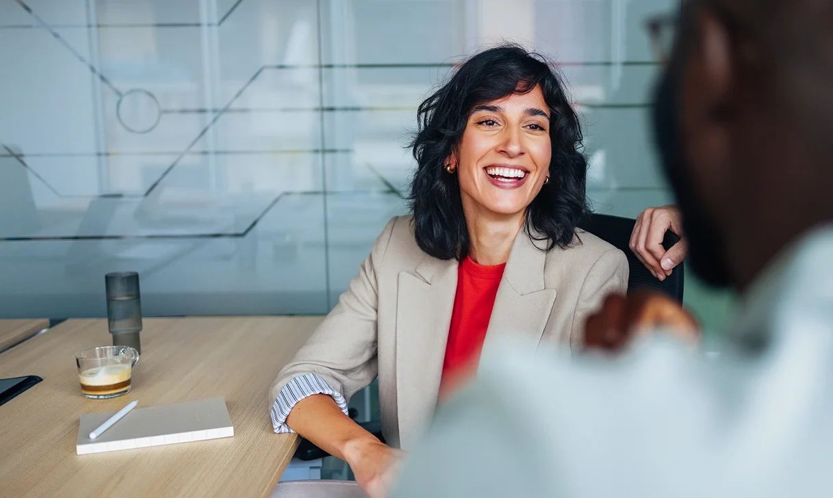 Smiling woman in professional interview setting.